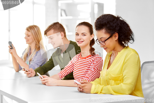 Image of happy high school students with smartphones