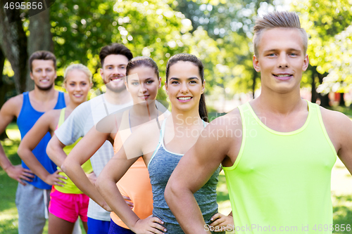 Image of group of happy friends or sportsmen at summer park