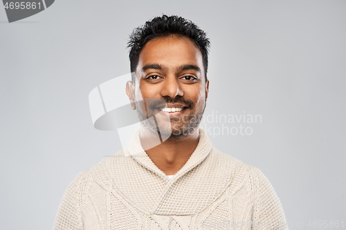 Image of indian man in knitted sweater over gray background