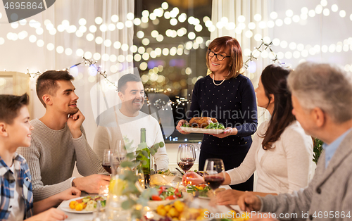 Image of happy family having dinner party at home