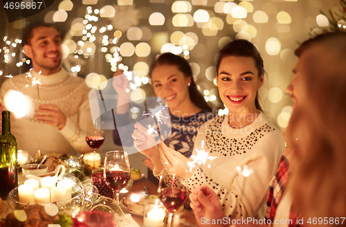 Image of happy friends celebrating christmas at home feast