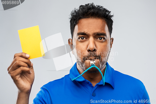 Image of indian referee whistling and showing yellow card