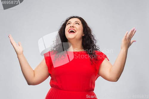 Image of happy smiling woman in red dress looking up