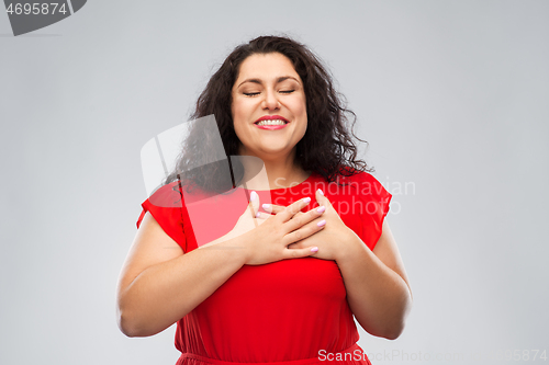 Image of happy woman holding hands on chest or heart