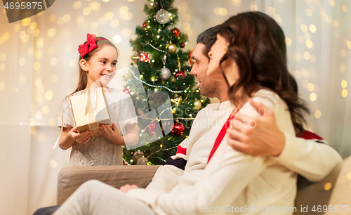 Image of happy family with christmas present at home