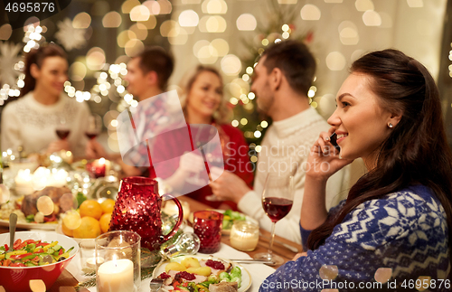 Image of woman calling on smartphone at christmas dinner