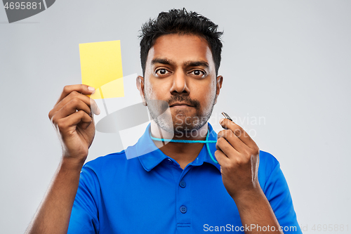 Image of indian referee whistling and showing yellow card