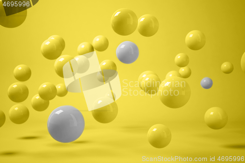 Image of 3D render of scattered yellow and grey balls levitating on yellow background