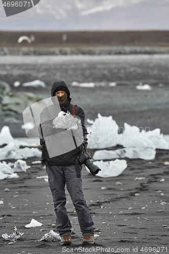 Image of Photographer picking up pieces of icebergs