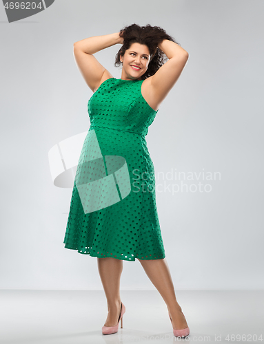 Image of happy woman in green dress over posing