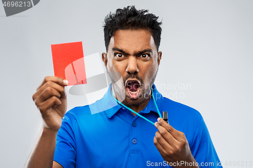 Image of angry indian referee with whistle showing red card