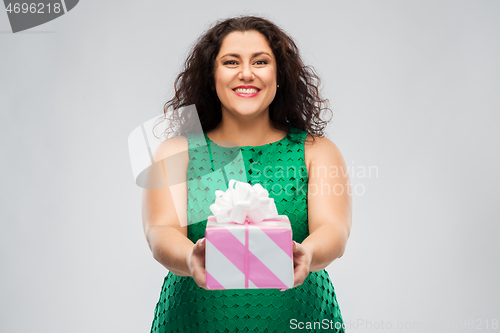 Image of happy woman in green dress holding gift box