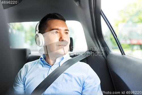 Image of passenger in headphones listening to music in car