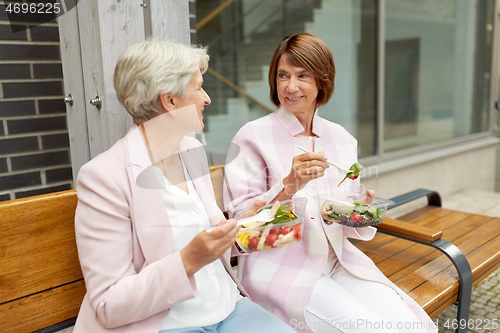 Image of senior women eating takeaway food on city street