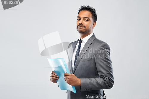 Image of indian businessman with folder over grey
