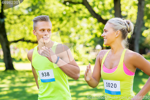 Image of happy couple of sportsmen racing wit badge numbers