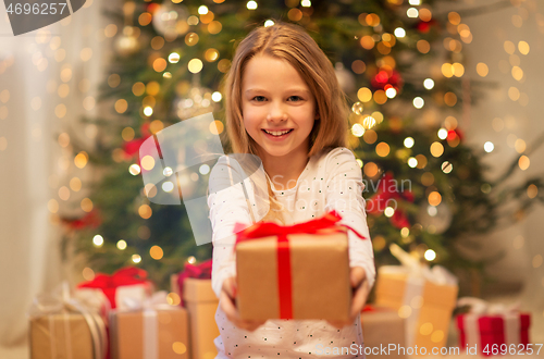 Image of smiling girl with christmas gift at home