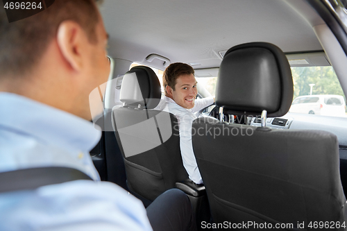 Image of male driver driving car with passenger