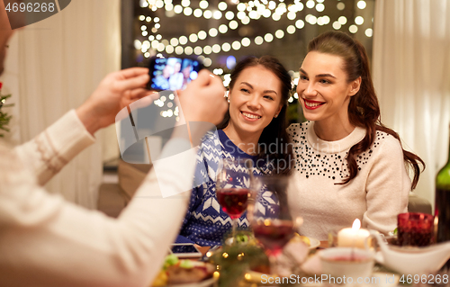 Image of friends having christmas dinner and taking picture