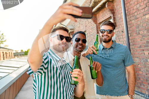 Image of men drinking beer and taking selfie by smartphone