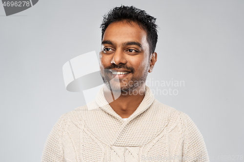 Image of indian man in knitted sweater over gray background