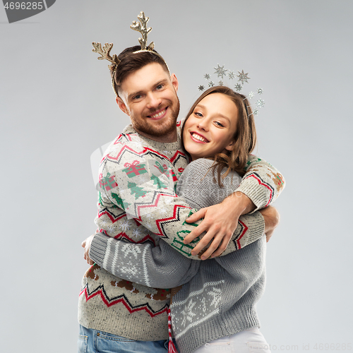 Image of happy couple at christmas ugly sweater party