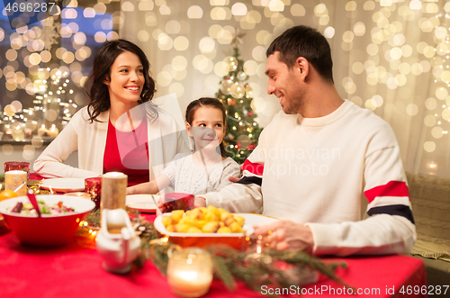 Image of happy family having christmas dinner at home