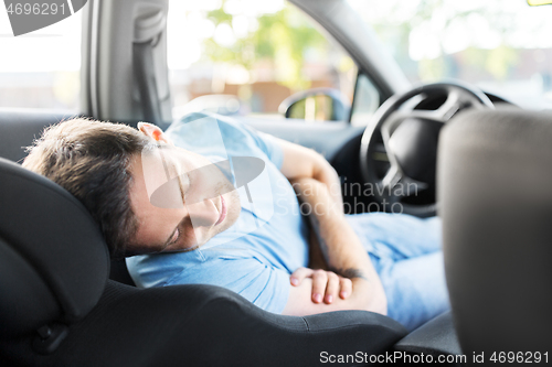 Image of tired man or driver sleeping in car