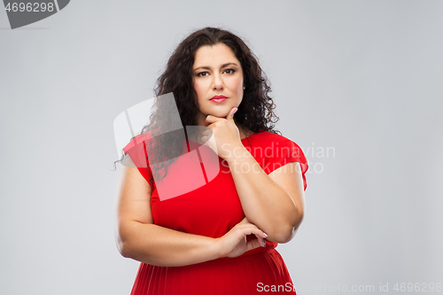 Image of serious woman in red dress thinking