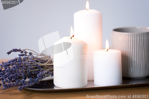 Image of candles, tea in mug and lavender flowers on table