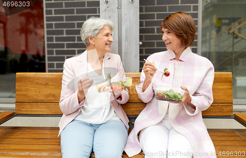 Image of senior women eating takeaway food on city street