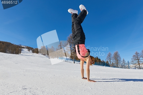 Image of Woman doing hand stand on a ski track in sunlight