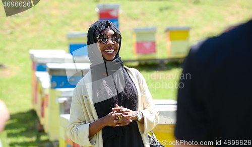 Image of woman giving presentation to group of business investors on local honey production farm