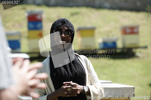 Image of woman giving presentation to group of business investors on local honey production farm