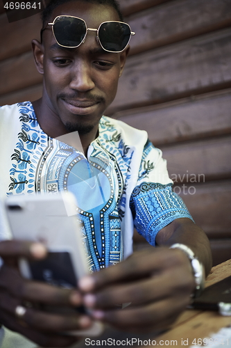 Image of native african black man using smart phone