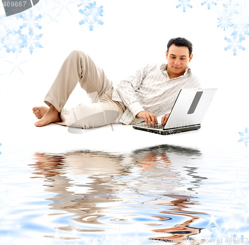 Image of relaxed man with laptop on white sand
