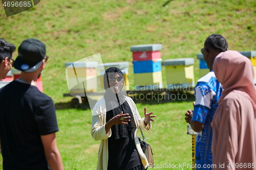 Image of woman giving presentation to group of business investors on local honey production farm