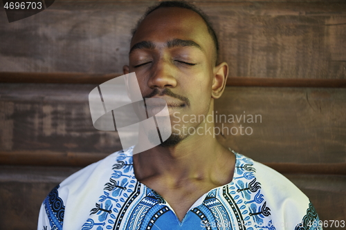 Image of portrait of a smiling young african man wearing traditioinal clothes