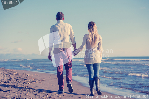 Image of Loving young couple on a beach at autumn sunny day