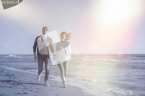 Image of Loving young couple on a beach at autumn sunny day