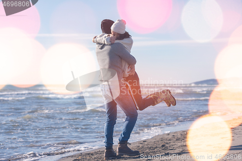 Image of Loving young couple on a beach at autumn sunny day