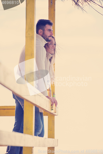 Image of young couple drinking beer together at the beach