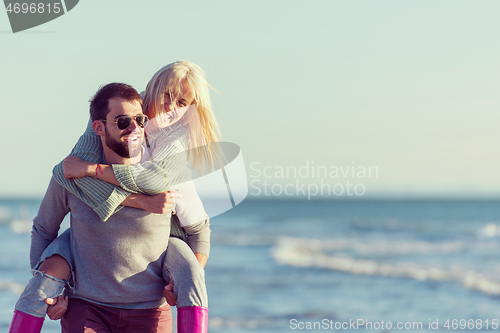 Image of couple having fun at beach during autumn