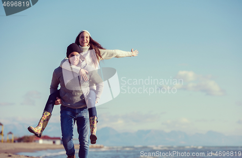 Image of couple having fun at beach during autumn