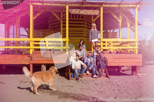 Image of Group of friends having fun on autumn day at beach