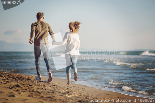 Image of Loving young couple on a beach at autumn sunny day