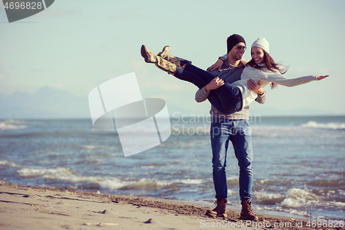 Image of Loving young couple on a beach at autumn sunny day