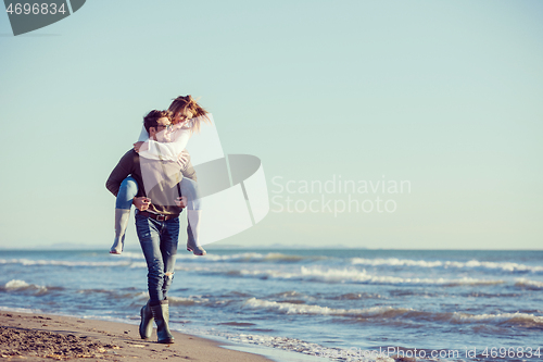 Image of couple having fun at beach during autumn