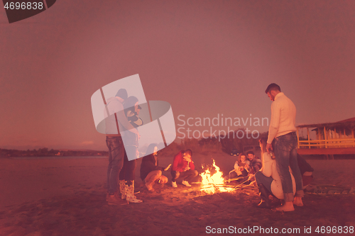 Image of Friends having fun at beach on autumn day