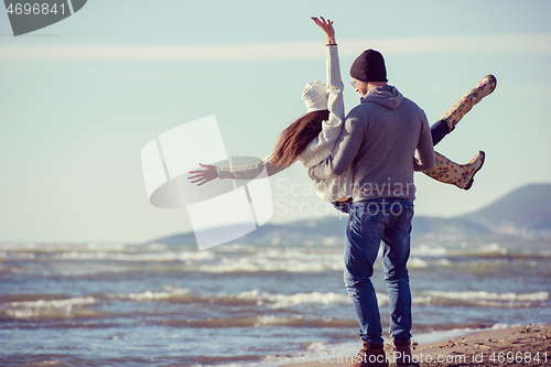 Image of Loving young couple on a beach at autumn sunny day